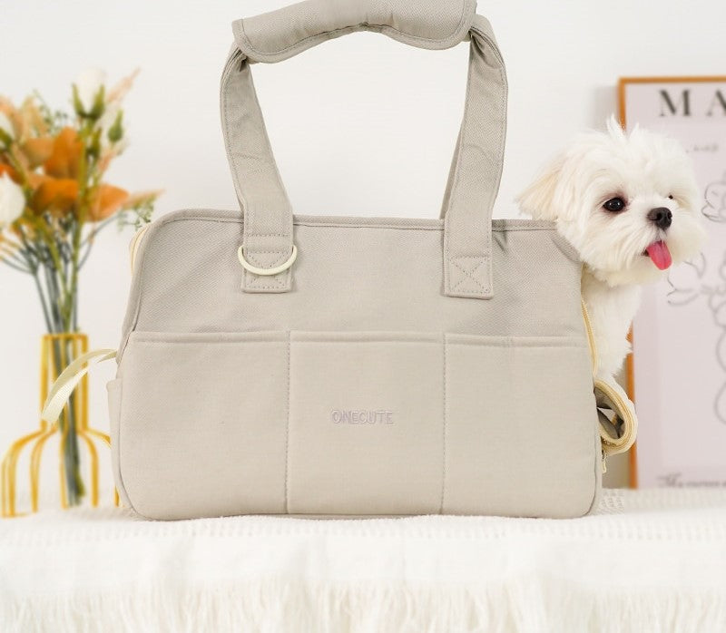 Image of small pet carrier with small dog inside on right